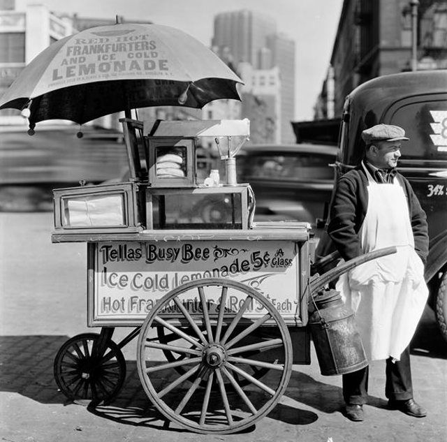 A street vendor selling hot dogs and lemonade at West and North Moore Streets, April 8th, 1936.
